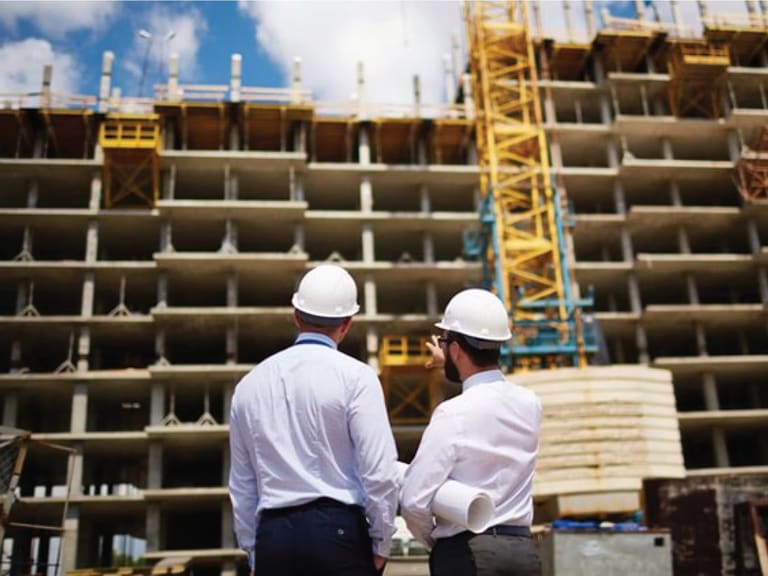 Réunion de chantier autour des plans entre les intervenants d'un projet de construction